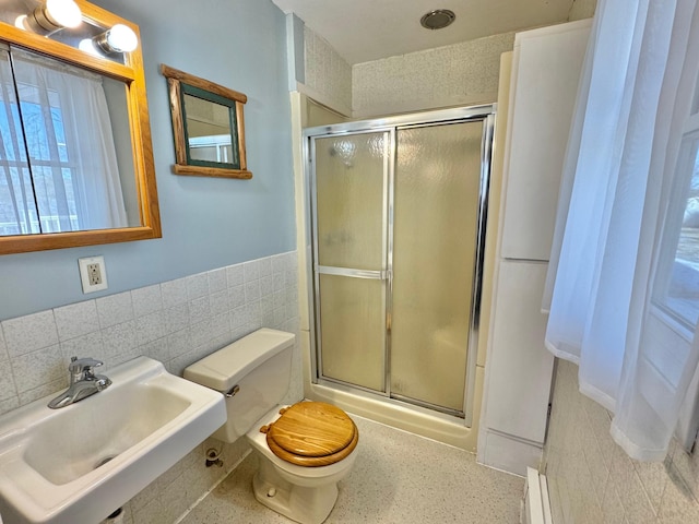 34257 Dusty Trl, Frazee, MN 56544 - full bath featuring a sink, toilet, a shower with door, tile walls, and a wainscoted wall