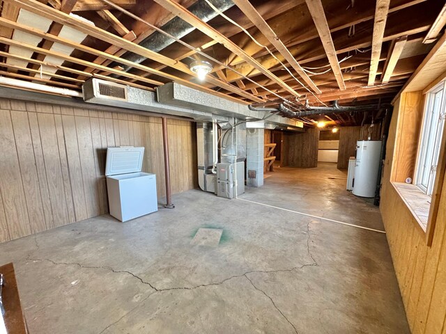 34257 Dusty Trl, Frazee, MN 56544 - unfinished below grade area featuring water heater, heating unit, fridge, and wood walls