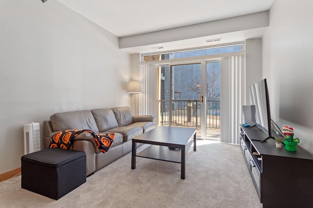 living room with a wealth of natural light, light carpet, and visible vents