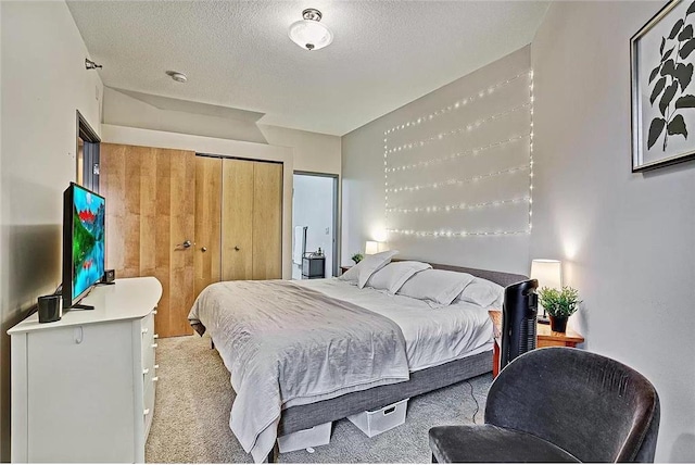 bedroom with light carpet, a textured ceiling, and a closet