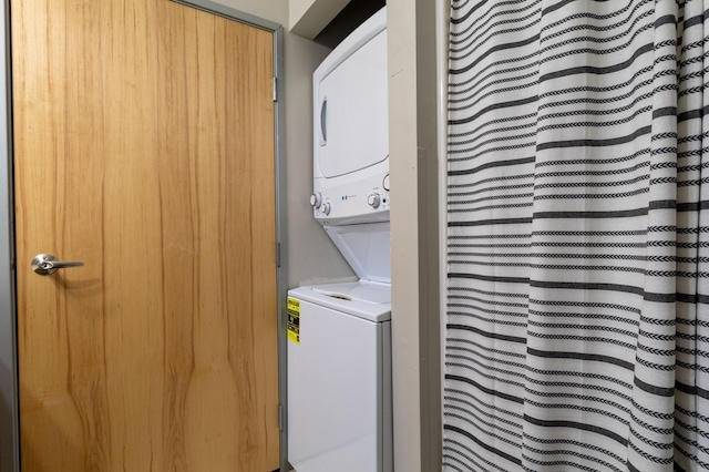 clothes washing area with stacked washer and dryer and laundry area