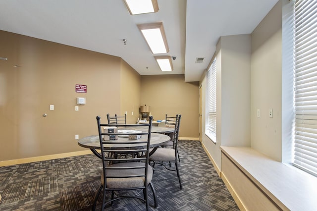 dining room with visible vents, dark carpet, and baseboards