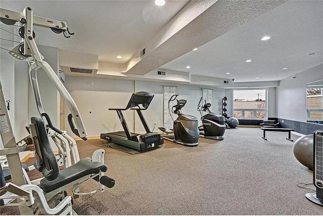 workout area with visible vents, a textured ceiling, and recessed lighting