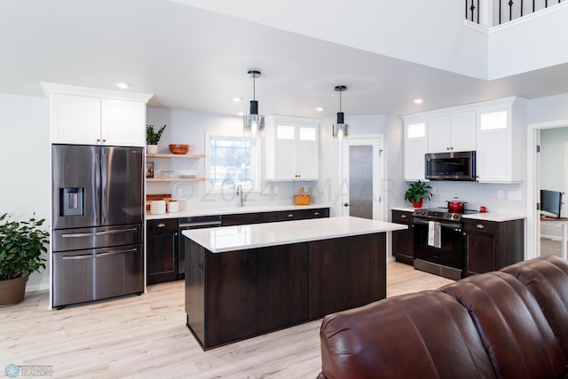 kitchen featuring white cabinets, appliances with stainless steel finishes, light countertops, and a sink