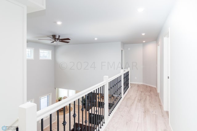 hall with recessed lighting, baseboards, wood finished floors, and an upstairs landing