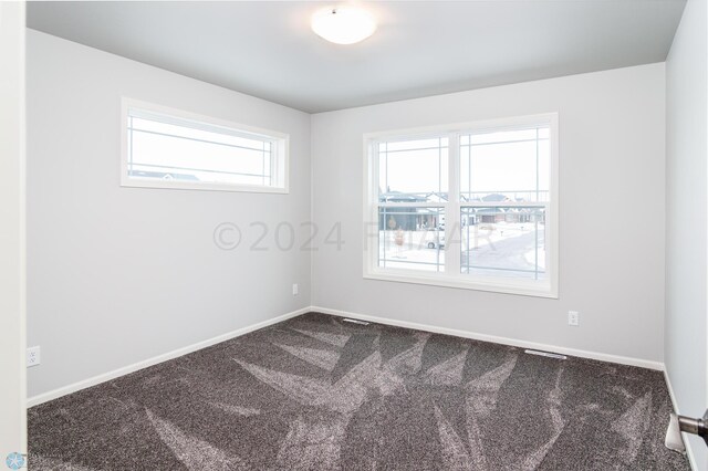 carpeted empty room with visible vents and baseboards