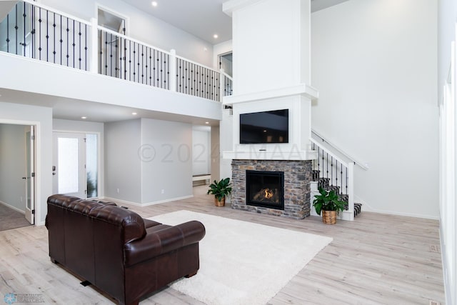 living area featuring baseboards, wood finished floors, and a fireplace