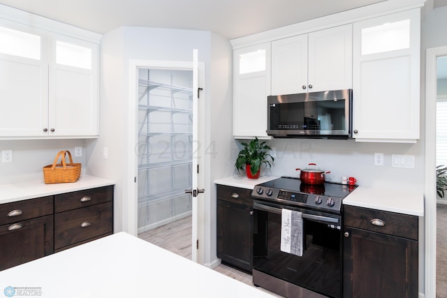 kitchen with light countertops, white cabinets, dark brown cabinets, and stainless steel appliances