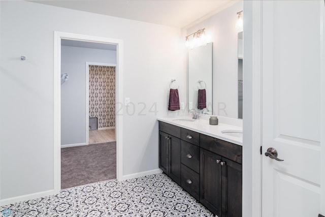 full bathroom with double vanity, tile patterned flooring, baseboards, and a sink