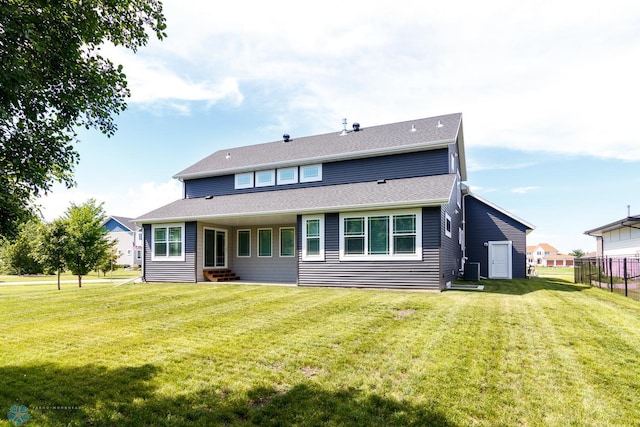 back of property featuring a lawn and entry steps