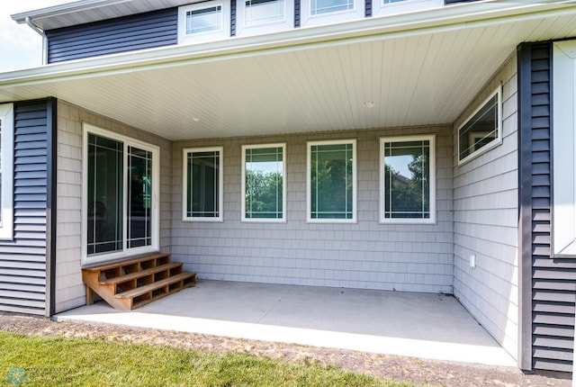 doorway to property featuring a patio and an attached carport