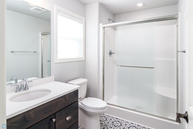 bathroom with vanity, a shower stall, toilet, and visible vents