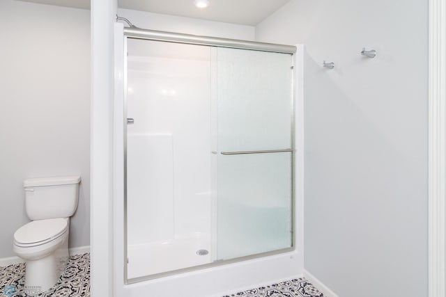 full bath with tile patterned flooring, a stall shower, and baseboards