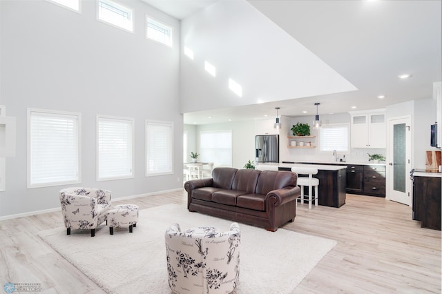 living room featuring light wood-style floors, baseboards, and a wealth of natural light