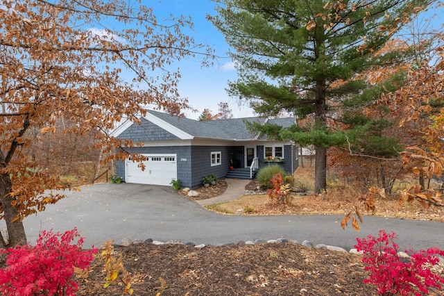 single story home featuring an attached garage and aphalt driveway