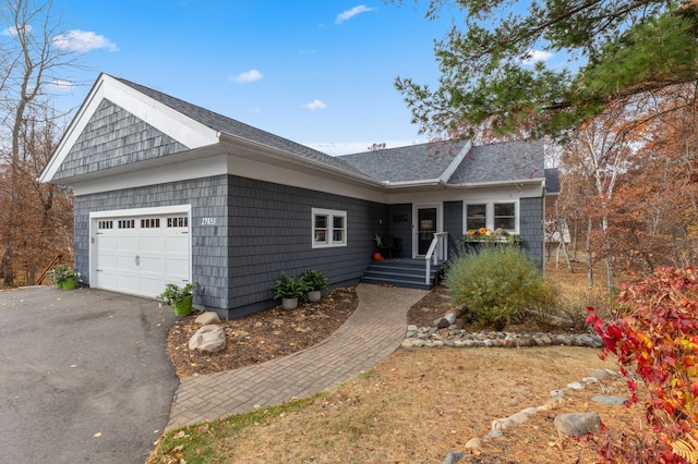 ranch-style house with a garage, driveway, and a shingled roof