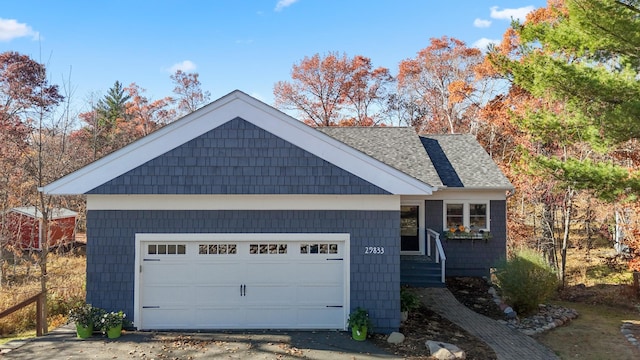 ranch-style house featuring a shingled roof and a garage