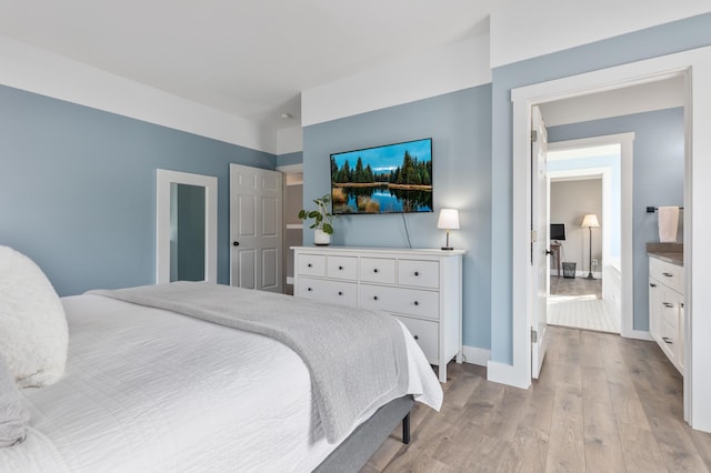 bedroom with light wood-style flooring and baseboards