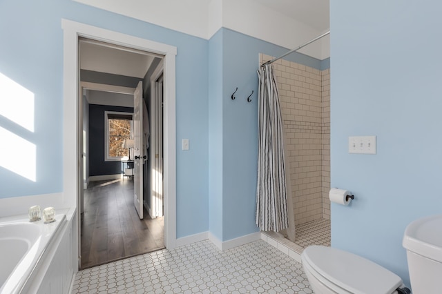 full bathroom with toilet, a shower stall, baseboards, and a bath