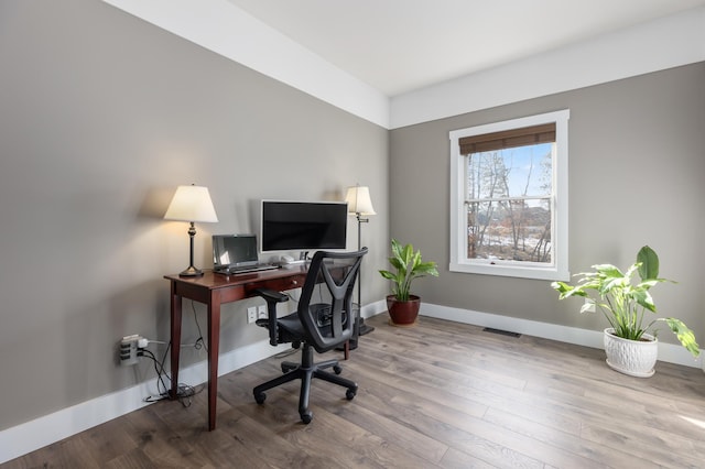 office featuring visible vents, baseboards, and wood finished floors