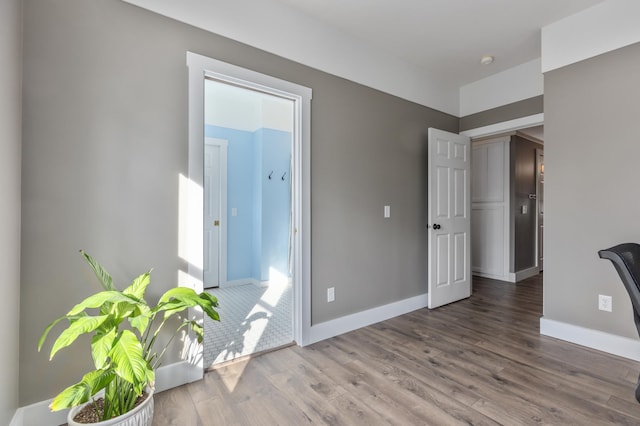 spare room with baseboards and wood finished floors