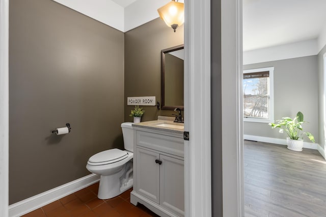 bathroom featuring vanity, toilet, and baseboards