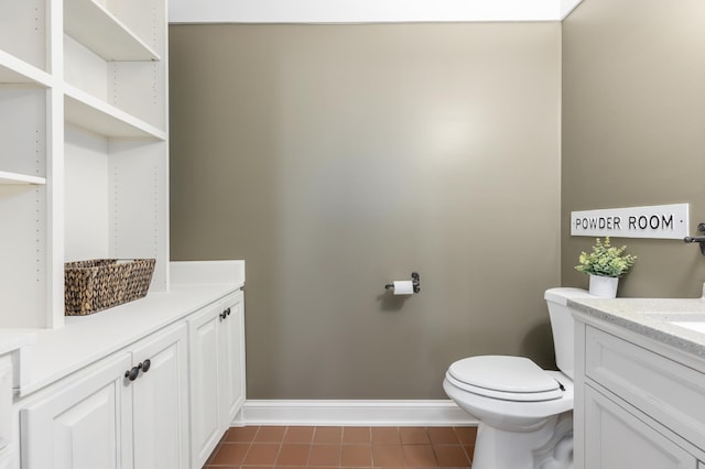 half bathroom with tile patterned flooring, baseboards, vanity, and toilet