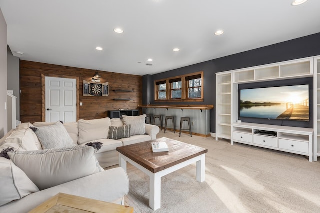 carpeted living room with recessed lighting and wooden walls