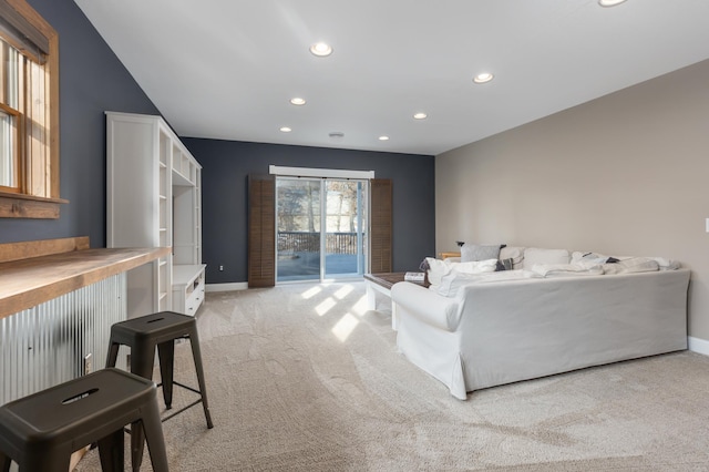 living area featuring recessed lighting, light carpet, a dry bar, and baseboards