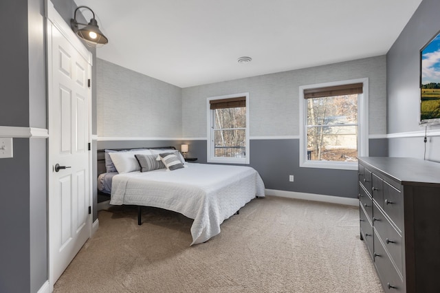 bedroom with light colored carpet and baseboards