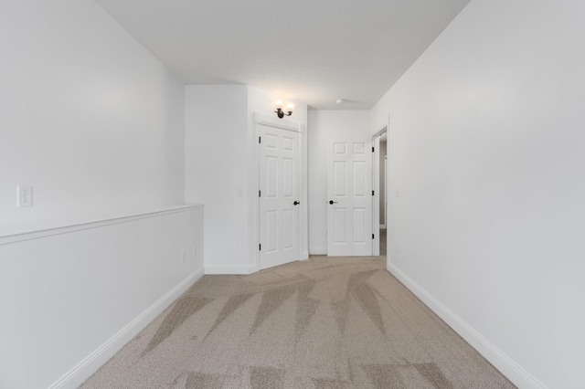 corridor with carpet floors and baseboards