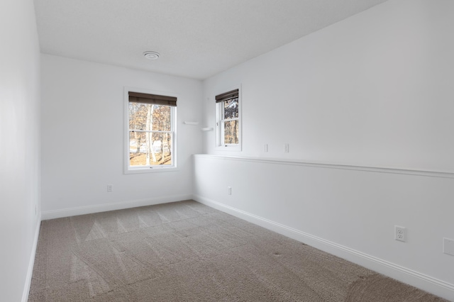 unfurnished room featuring carpet floors and baseboards