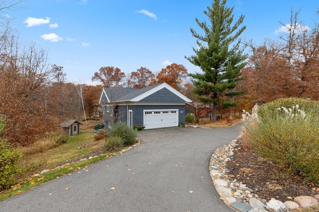 view of side of home featuring a garage and aphalt driveway