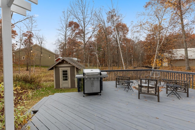 deck featuring a storage shed, an outdoor structure, and a grill