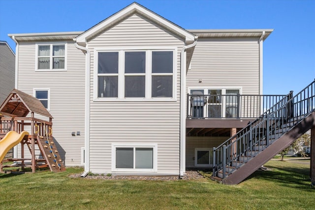 rear view of house featuring a yard, stairs, and a playground