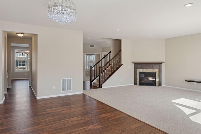 living area with visible vents, stairs, baseboards, and wood finished floors