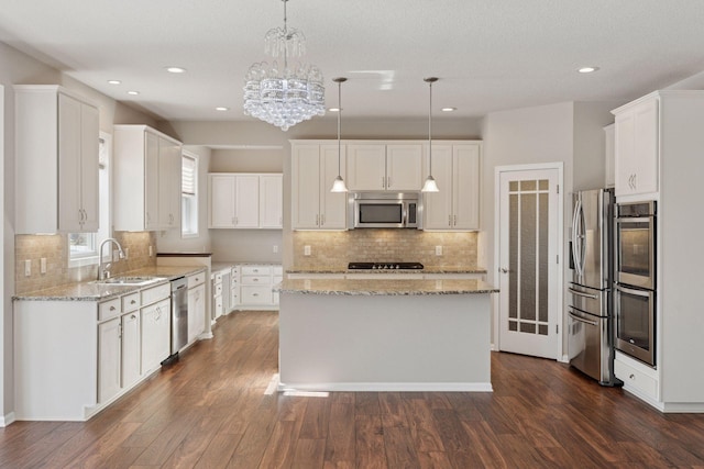 kitchen with a sink, white cabinets, dark wood finished floors, and stainless steel appliances