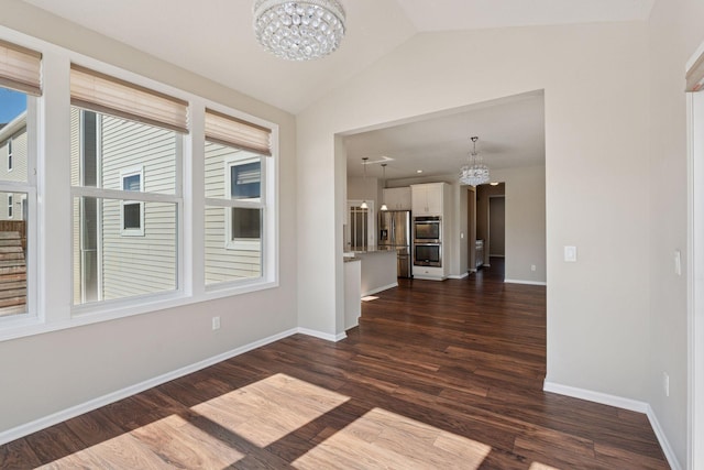 interior space featuring dark wood finished floors, a notable chandelier, baseboards, and lofted ceiling