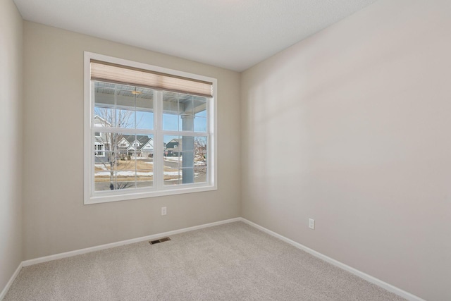 unfurnished room with visible vents, baseboards, and carpet