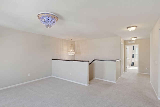 spare room with baseboards, visible vents, carpet floors, and a textured ceiling