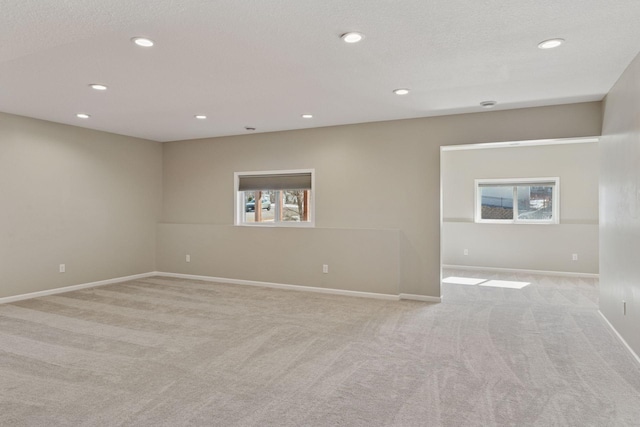 unfurnished room with recessed lighting, light colored carpet, and baseboards