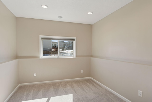 empty room featuring recessed lighting, baseboards, and carpet