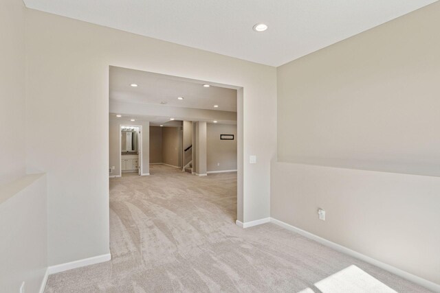 empty room with stairs, recessed lighting, light colored carpet, and baseboards