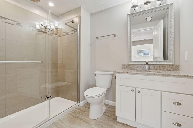 full bathroom featuring toilet, a textured ceiling, a shower stall, baseboards, and vanity