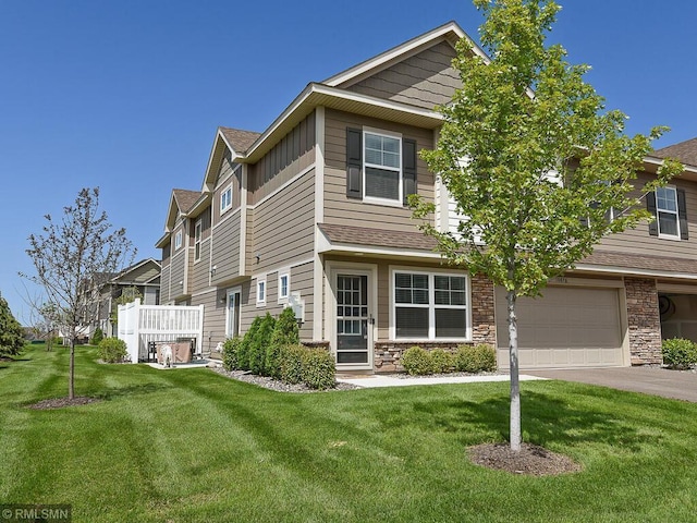 view of front of property with board and batten siding, a front yard, stone siding, and aphalt driveway