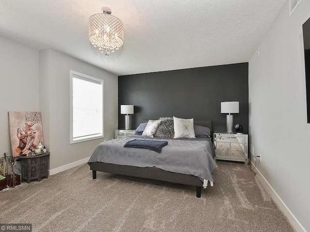 carpeted bedroom with visible vents, a notable chandelier, a textured ceiling, and baseboards