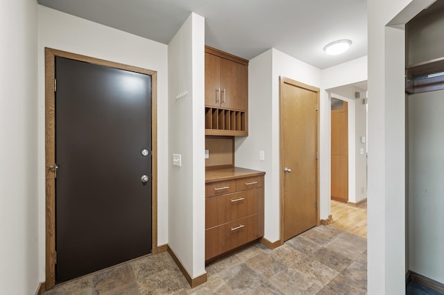 hall with stone finish floor and baseboards