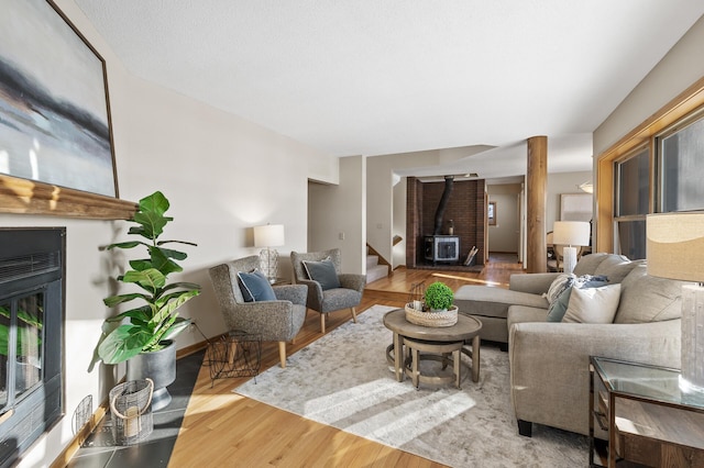 living area featuring wood finished floors, visible vents, baseboards, and stairs