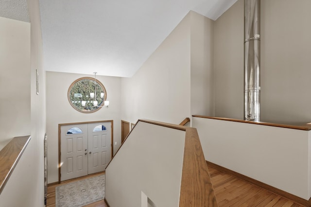 entryway with baseboards, a chandelier, and wood finished floors