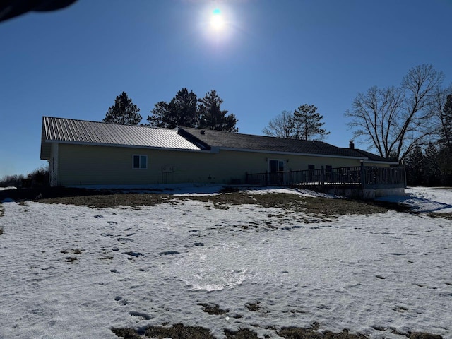 snow covered property featuring metal roof